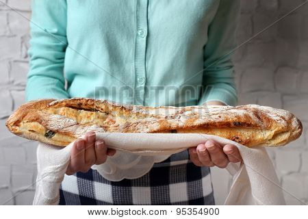 Woman holding tasty fresh bread, close up