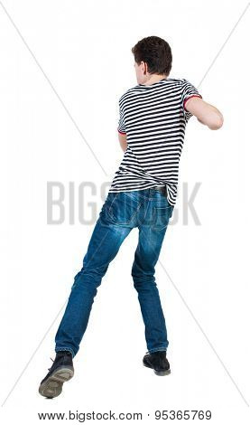 back view of skinny guy funny fights waving his arms and legs. Isolated over white background. backside view of person. Funny guy clumsily boxing. The guy in the striped shirt in the backswing.