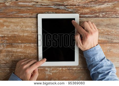 business, education, people and technology concept - close up of male hands with tablet pc computer on table