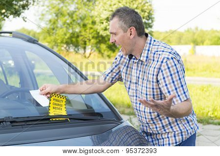 Suprised man looking on parking ticket placed under windshield wiper