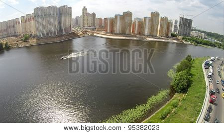 RUSSIA, KRASNOGORSK - JUN 6, 2014: Riverscape and tall dwelling houses on shore at summer day. Aerial view. Photo with noise from action camera