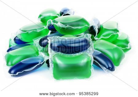 closeup of a pile of liquid laundry detergent sachets on a white background