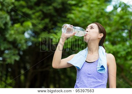 Woman drinking with water at park
