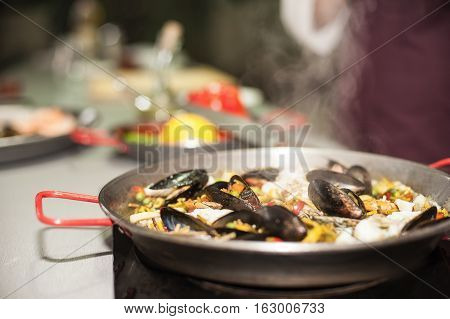 Italian pasta fideua with seafood, oysters, black pasta