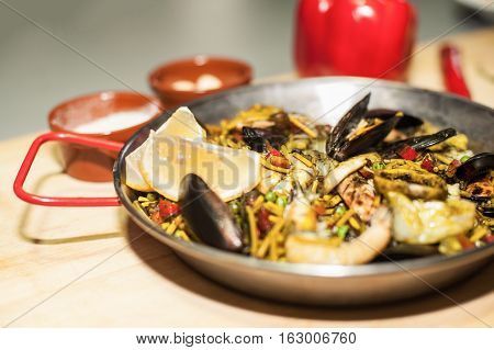 Italian pasta fideua with seafood, oysters, black pasta
