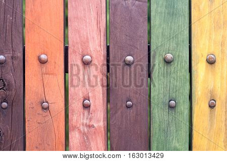 Colorful fence with nails close up. Red, purple, yellow, green. Old.