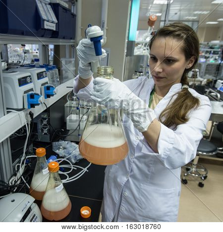 Woman Laboratory Assistant With Flask In His Hand In The Biochemical Laboratory