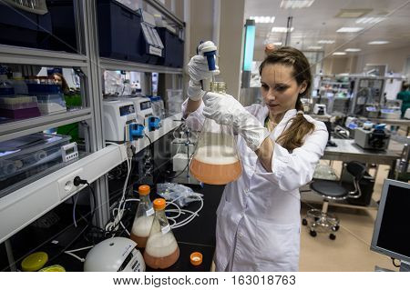 Woman Laboratory Assistant With Flask In His Hand In The Biochemical Laboratory