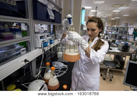 Woman Laboratory Assistant With Flask In His Hand In The Biochemical Laboratory
