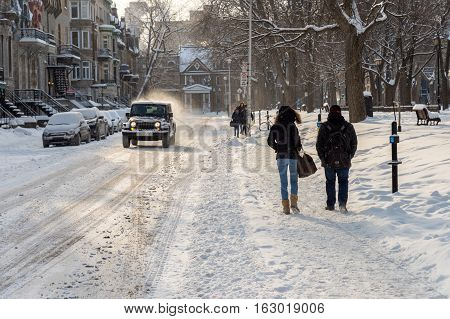 Montreal CA - 17 December 2016: Snowstorm in Montreal. Pedestrians walking near Square Saint-Louis