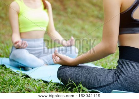 Two Young girl doing yoga in the park.