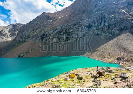 The Tourists On The Shore Of A Mountain Lake Ala-kul, Kyrgyzstan.