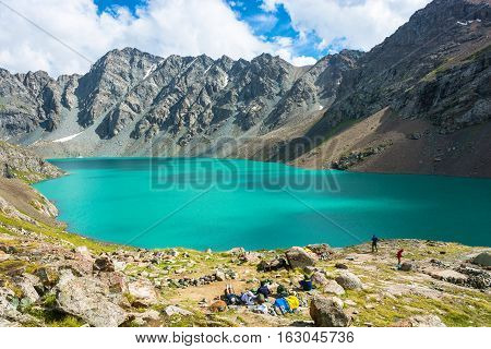 The Tourists On The Shore Of A Mountain Lake Ala-kul, Kyrgyzstan.