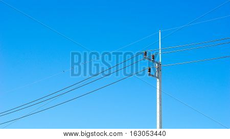 Electric pole and blue sky concept - Electric pole with blue clear sky and little bird on cable in industrial estate with copyspace