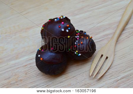 Delicious and soft fresh homemade chocolate ball cake topping with candy sprinkle on wooden board