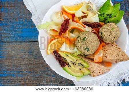 Zucchini pasta with tofu lentil balls avocado carrots. Vegan healthy lunch or dinner. Love for a healthy raw food