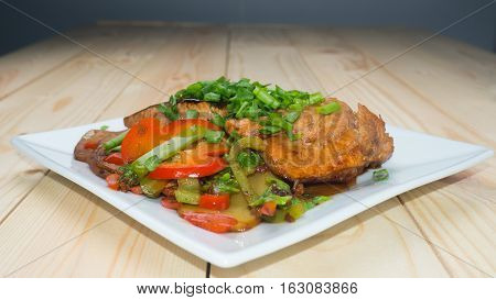 Trout marinated in soy sauce with vegetables. Front view