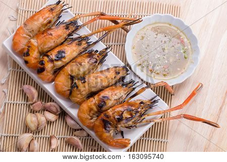 Burn Shrim And Seafood Sauce On Wooden Table.