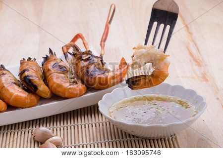 Burn Shrim And Seafood Sauce On Wooden Table.