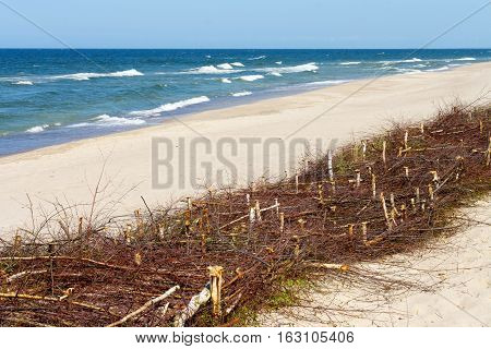 fascine cage made of tree branches to keep the sand on the beach. Protective structures