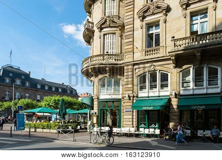 STRASBOURG FRANCE - JUL 4 2016: Vintage Cafe Broglie in central Strasbourg with people sitting on the outdoor tables enjoying cups of coffee and tea eating french sweets