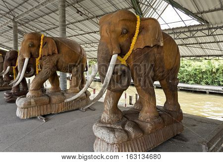 BANGKOK, THAILAND - November 5, 2016: Ceramic statues of full size elephants on a river cruise terminal near the floating markets of Bangkok Thailand