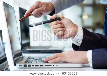 Team work process. young business managers crew working with new startup project. labtop on wood table typing keyboard texting message analyze graph plans.