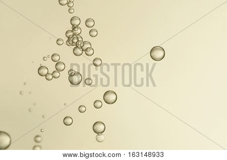 Golden bubbles folws over yellow gradient background