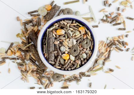 dry food for rodents in bowl on white background top view.