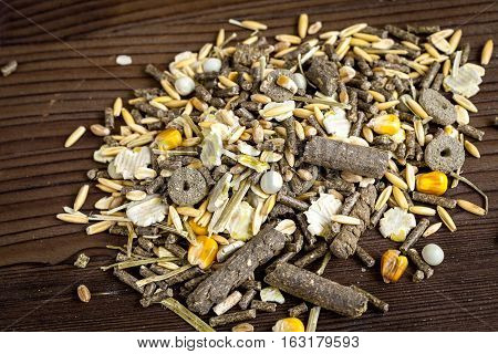 dry food for rodents on dark wooden background