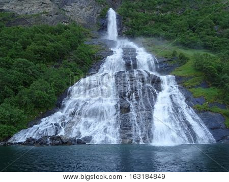 Interesting picturesque waterfall Suitor Geiranger fjord summer day