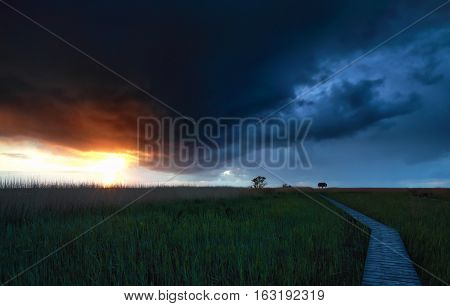 stormy sky over wooden path at sunset Groningen Netherlands