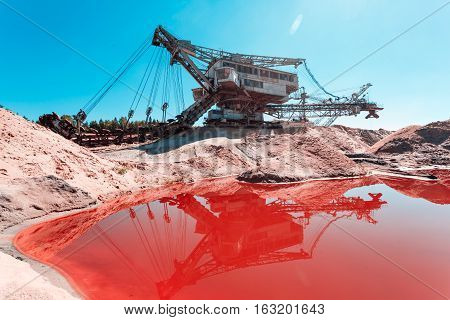 multi bucket excavator, giant stacker, absetzer in career. red water rich in minerals
