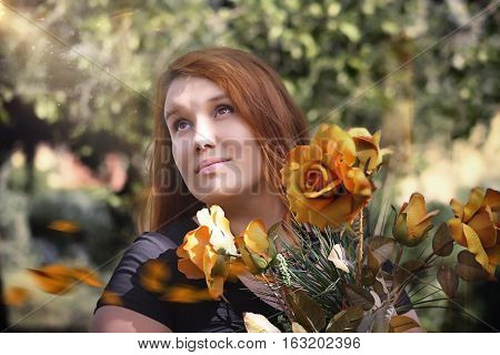 the girl with red hair in the Park among the flowers