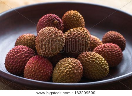 Healthy eating. Several lychee in an earthenware plate.
