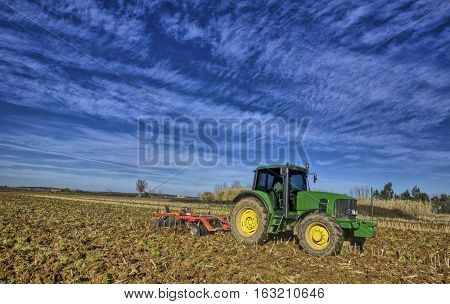 Farm tractor preparing the soil and ranking the field before planting Montijo Badajoz Extremadura Spain