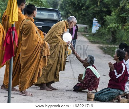 Buddhist give alms to a Buddhist monk Ban Namon Kalasin province Thailand in the morning on November 12 2016.