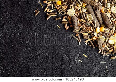 dry food for rodents on dark background top view.