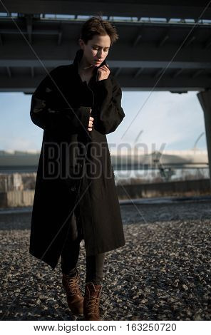 Young stylish woman urban walking under bridge