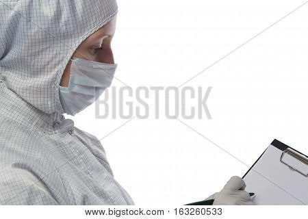 woman in a protective suit is writing on paper