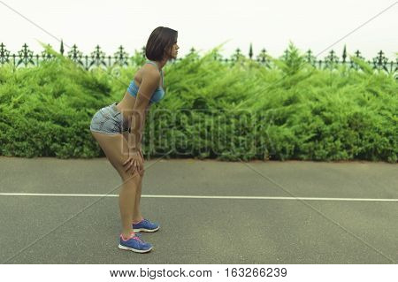 a woman stands on the road in the Park before the morning jog