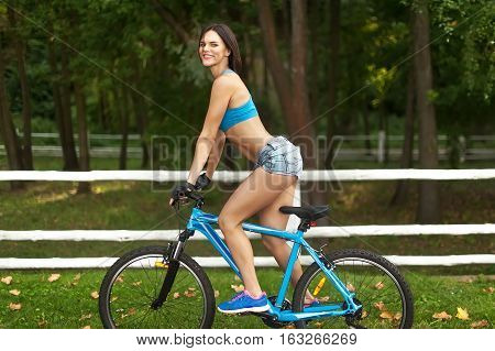 a woman rides her Bicycle on the road in the Park
