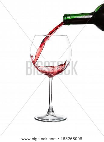 Red wine pouring in glass on white background