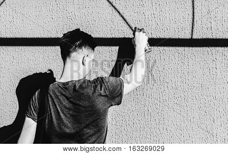 Man writing graffiti on the urban walls