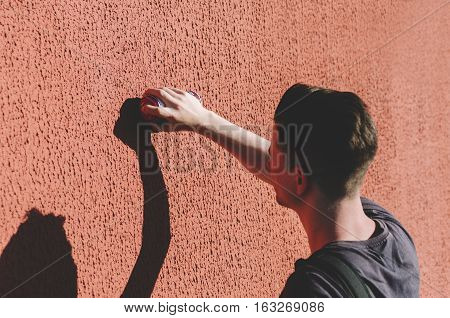Man writing graffiti on the urban walls