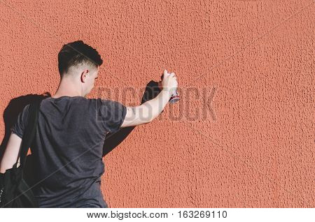Man writing graffiti on the urban walls