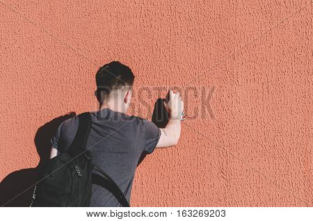 Man writing graffiti on the urban walls