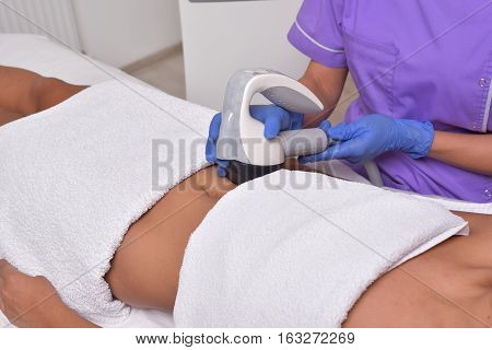 Young beautiful woman gets professional skin treatment in a beauty clinic. Body shaper