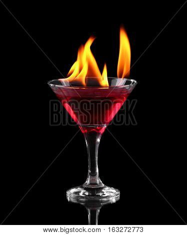 Flaming cocktail in glass over black background