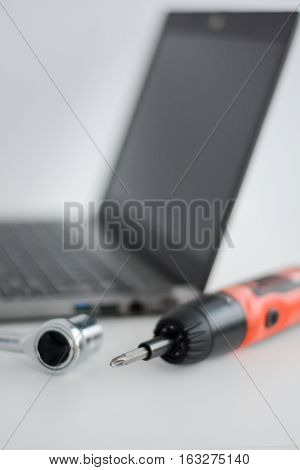 Computer support with a notebook and screwdriver